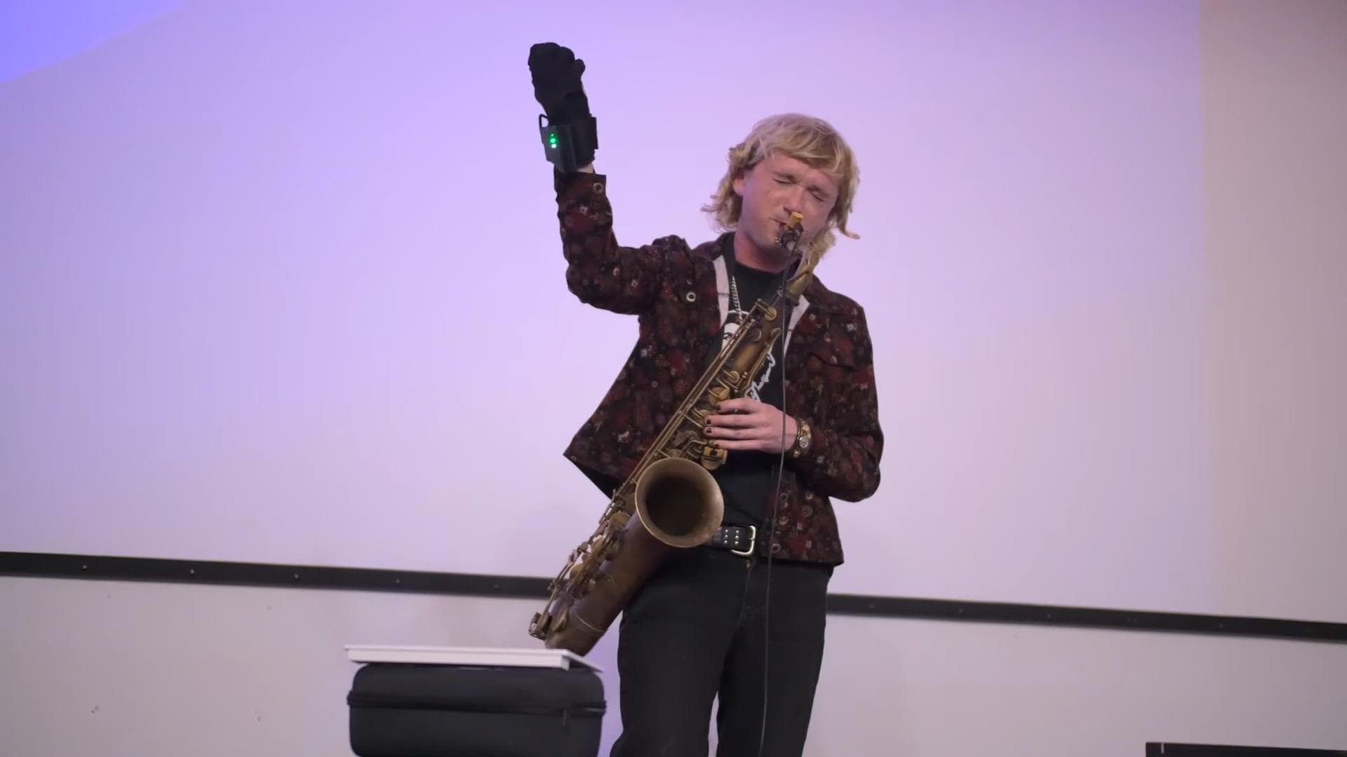 performer with saxophone and glove controller